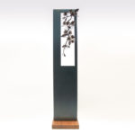 青みを残して黒焼きした鉄のプレートの窓から、鍛鉄の桜の枝が下がっている姿のアート作品です。正面写真。