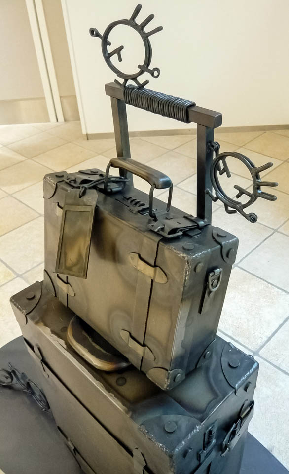 横浜ノースポートモールにオープン時設置されていたアートオブジェ「急ぐヤツら」。忘れ物のバッグや鞄を届けるために駅へと急いでいる彫刻作品です。全て鉄で制作されました。旅行カバンを運ぶ作品。