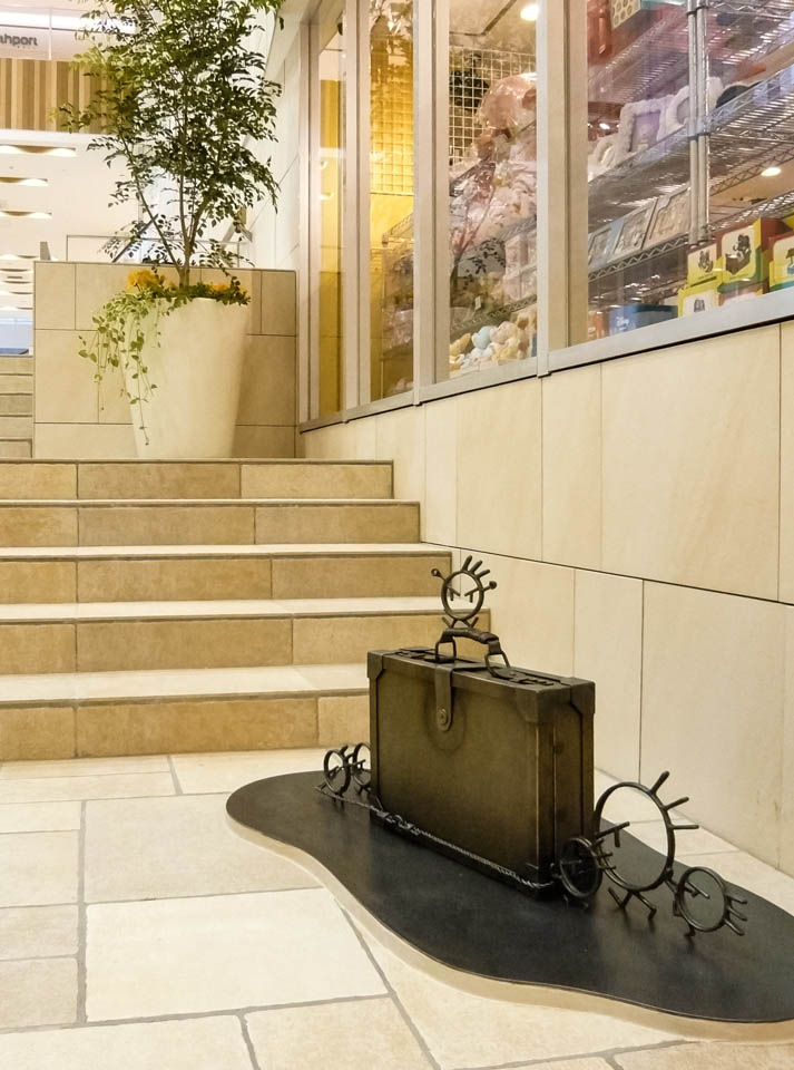 横浜ノースポートモールにオープン時設置されていたアートオブジェ「急ぐヤツら」。忘れ物のバッグや鞄を届けるために駅へと急いでいる彫刻作品です。全て鉄で制作されました。ビジネスバッグを運ぶ作品。