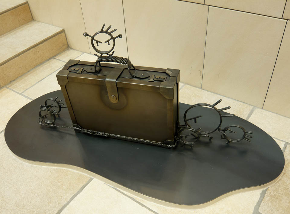 横浜ノースポートモールにオープン時設置されていたアートオブジェ「急ぐヤツら」。忘れ物のバッグや鞄を届けるために駅へと急いでいる彫刻作品です。全て鉄で制作されました。ビジネスバッグを運ぶ作品。