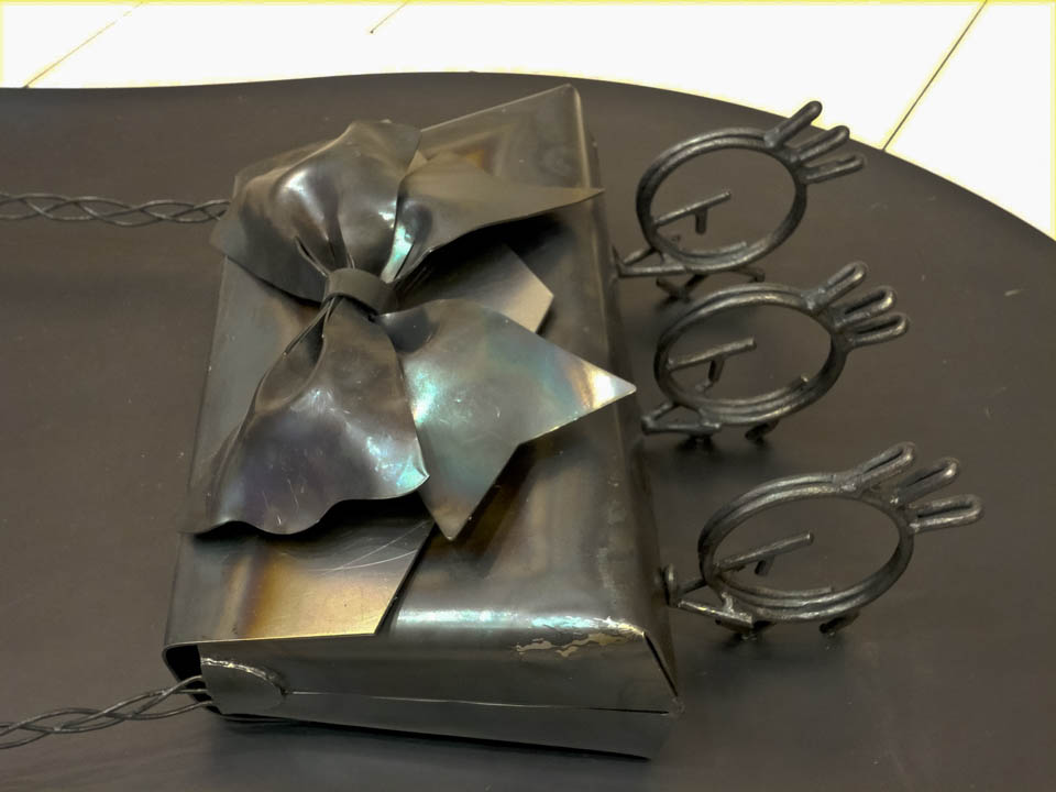 横浜ノースポートモールにオープン時設置されていたアートオブジェ「急ぐヤツら」。忘れ物のバッグや鞄を届けるために駅へと急いでいる彫刻作品です。全て鉄で制作されました。ハンドバッグを運ぶ作品。