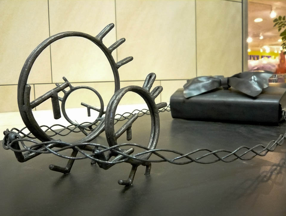 横浜ノースポートモールにオープン時設置されていたアートオブジェ「急ぐヤツら」。忘れ物のバッグや鞄を届けるために駅へと急いでいる彫刻作品です。全て鉄で制作されました。ハンドバッグを運ぶ作品。