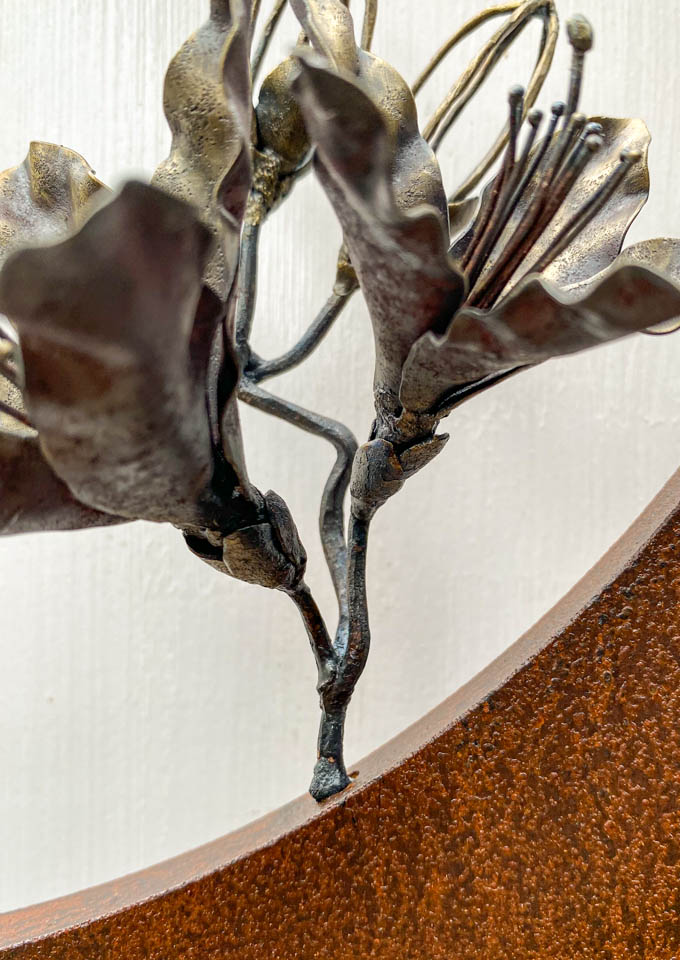 箱根の春を彩るミツバツツジの花を円弧に添えた鉄の彫刻、アート作品です。壁面へ取り付ける仕様になっています。蕾は鍛造した鉄線で表現し軽い印象になっています。円弧は厚みのある鉄を切り出し、下部でズラして表情をつけています。萼と茎の様子。