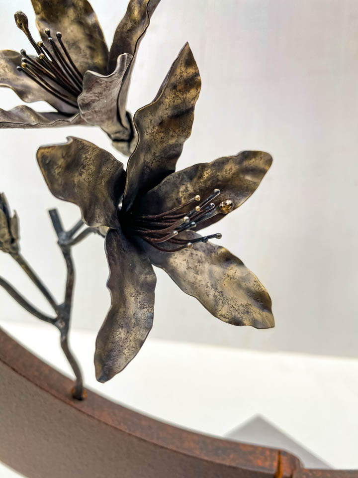 箱根の春を彩るミツバツツジの花を円弧に添えた鉄の彫刻、アート作品です。スタンドタイプです。蕾は鍛造した鉄線で表現し軽い印象になっています。円弧は厚みのある鉄を切り出し、下部でズラして表情をつけています。花の様子。