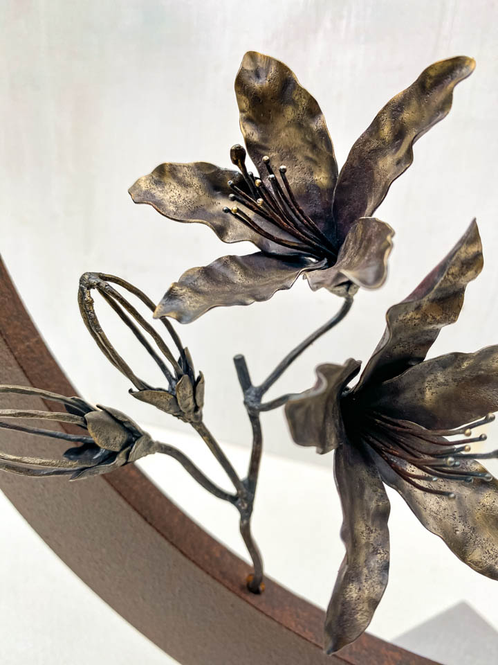 箱根の春を彩るミツバツツジの花を円弧に添えた鉄の彫刻、アート作品です。スタンドタイプです。蕾は鍛造した鉄線で表現し軽い印象になっています。円弧は厚みのある鉄を切り出し、下部でズラして表情をつけています。花の様子。
