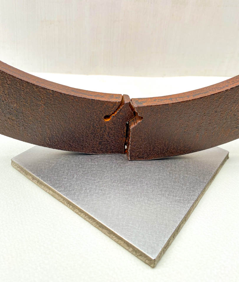 箱根の春を彩るミツバツツジの花を円弧に添えた鉄の彫刻、アート作品です。スタンドタイプです。蕾は鍛造した鉄線で表現し軽い印象になっています。円弧は厚みのある鉄を切り出し、下部でズラして表情をつけています。ベースの様子。