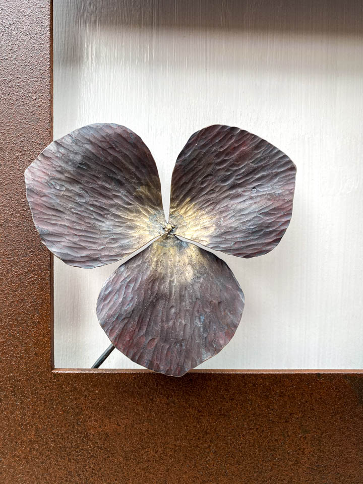 箱根に自制するエンレイソウの葉をモチーフにした鉄の彫刻、アート作品です。厚みのある鉄板に窓を開け、記号的なエンレイソウの葉が顔を出している、シンプルな構成です。葉の表面は丹念に鍛造しハンマートーンをはっきり付けて、中心部分を真鍮で磨き込み色味に変化をつけました。厚みのある鉄板は実際に錆びた風合いを残した仕上げとし、重厚な風合いを醸し出しています。