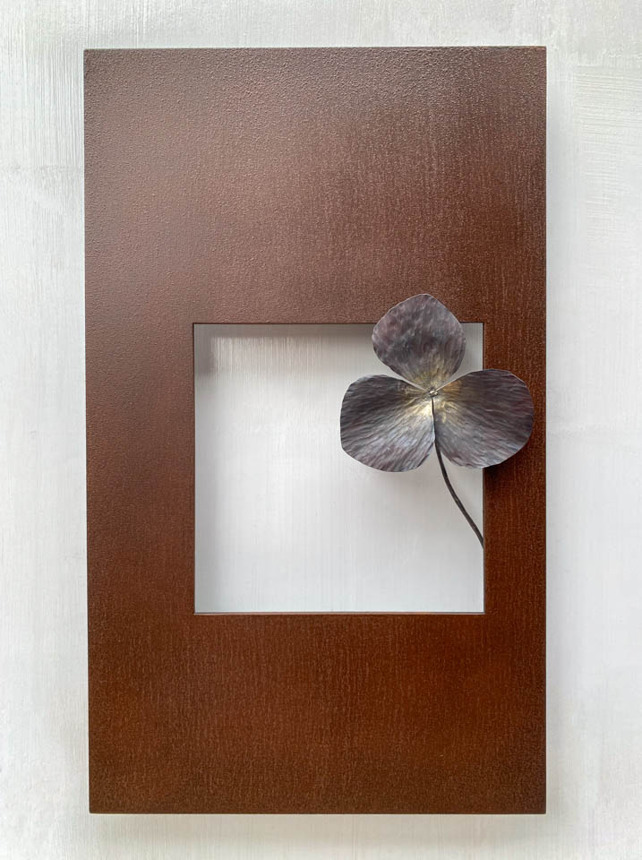 箱根に自制するエンレイソウの葉をモチーフにした鉄の彫刻、アート作品です。厚みのある鉄板に窓を開け、記号的なエンレイソウの葉が顔を出している、シンプルな構成です。葉の表面は丹念に鍛造しハンマートーンをはっきり付けて、中心部分を真鍮で磨き込み色味に変化をつけました。厚みのある鉄板は実際に錆びた風合いを残した仕上げとし、重厚な風合いを醸し出しています。