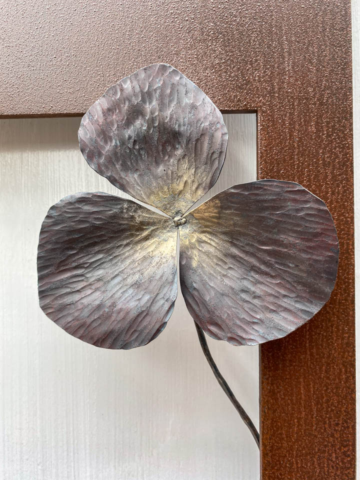 箱根に自制するエンレイソウの葉をモチーフにした鉄の彫刻、アート作品です。厚みのある鉄板に窓を開け、記号的なエンレイソウの葉が顔を出している、シンプルな構成です。葉の表面は丹念に鍛造しハンマートーンをはっきり付けて、中心部分を真鍮で磨き込み色味に変化をつけました。厚みのある鉄板は実際に錆びた風合いを残した仕上げとし、重厚な風合いを醸し出しています。