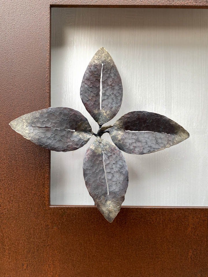 箱根に自制するヒトリシズカをモチーフにした鉄の彫刻、アート作品です。 厚みのある鉄板に窓を開け、ヒトリシズカがひと枝顔を出している構成です。４枚の葉の中央で、花芽はまだ小さく短い様子です。葉の表面は丹念に鍛造しハンマートーンをはっきり付けて、中心部分を真鍮で磨き込み色味に変化をつけました。葉の表情。