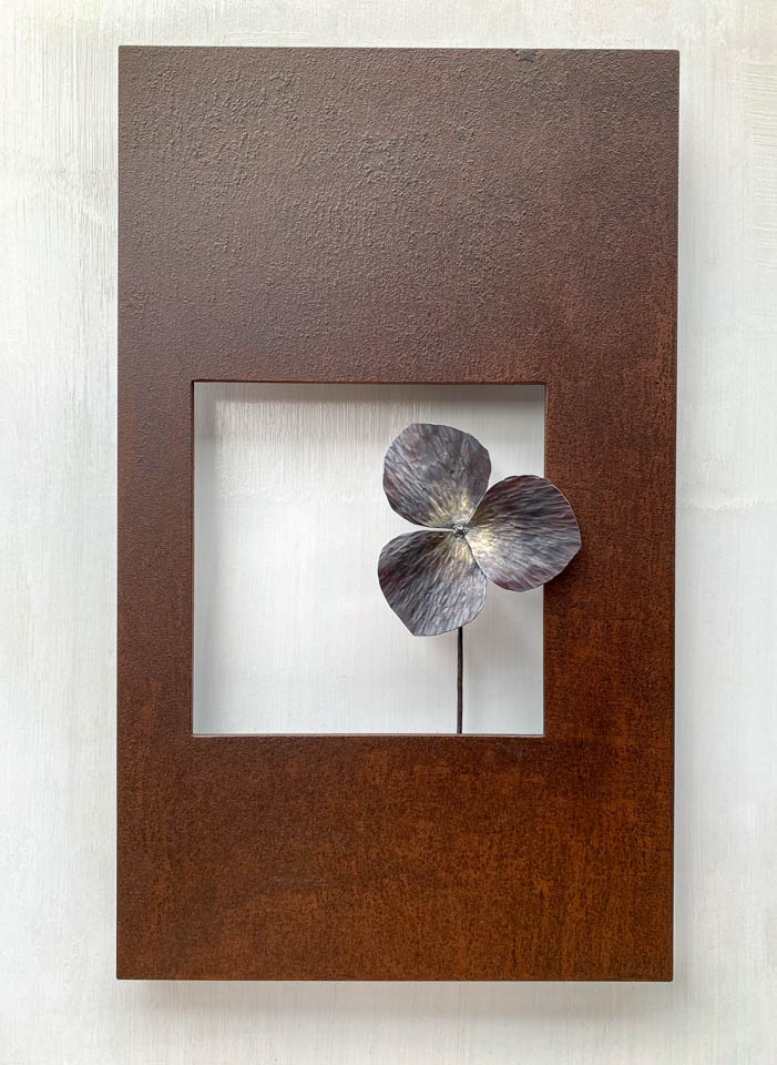 箱根に自制するエンレイソウの葉をモチーフにした鉄の彫刻、アート作品です。厚みのある鉄板に窓を開け、記号的なエンレイソウの葉が顔を出している、シンプルな構成です。葉の表面は丹念に鍛造しハンマートーンをはっきり付けて、中心部分を真鍮で磨き込み色味に変化をつけました。厚みのある鉄板は実際に錆びた風合いを残した仕上げとし、重厚な風合いを醸し出しています。