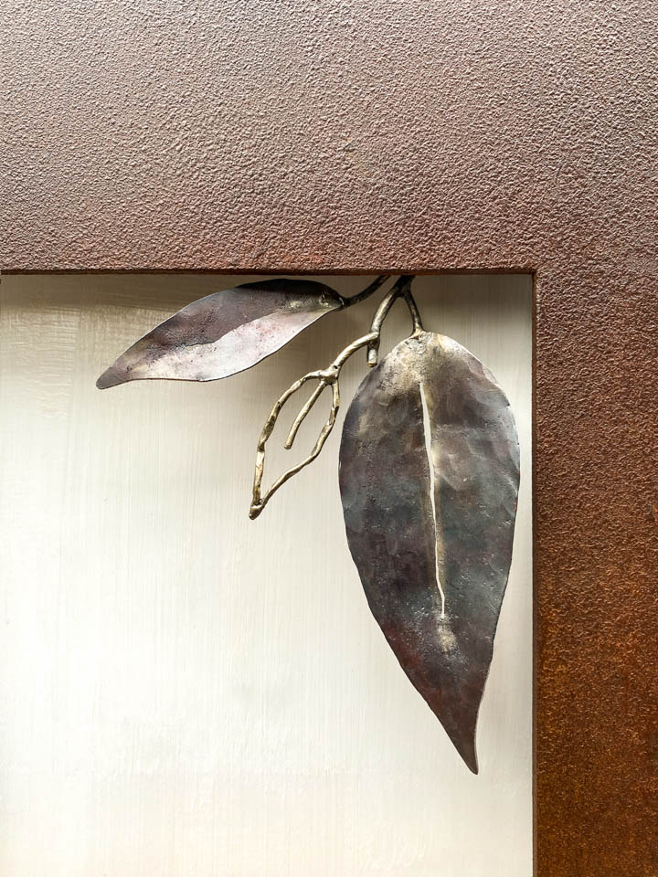 箱根に自制するマメザクラの葉をモチーフにした鉄の彫刻、アート作品です。 厚みのある鉄板に窓を開け、ひと枝顔を出している構成です。 葉は３枚とし、うち一枚は線の表現としました。 葉の表面は丹念に鍛造しハンマートーンをはっきり付けて、面の葉の中央に切り込みを入れ太い葉脈を表現しています。 厚みのある鉄板は実際に錆びた風合いを残した仕上げとし、重厚な風合いを醸し出しています。
