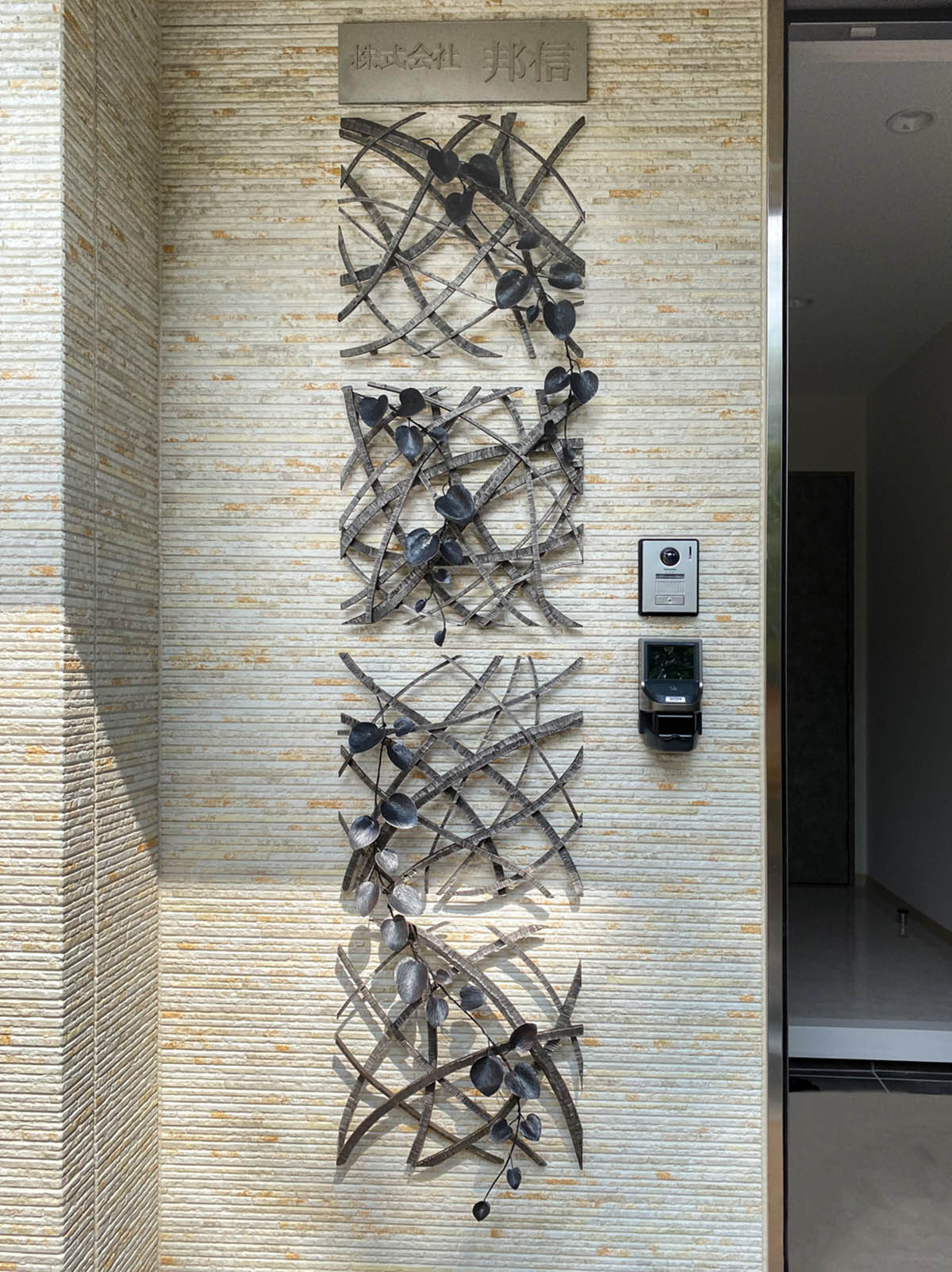 風をイメージしたラインを重ねたものに、カンガルーアイビーを配したアートオブジェ、彫刻作品です。 鉄で制作していたものを、ステンレスに置き換えて作りました。 壁に取り付ける仕様です。
