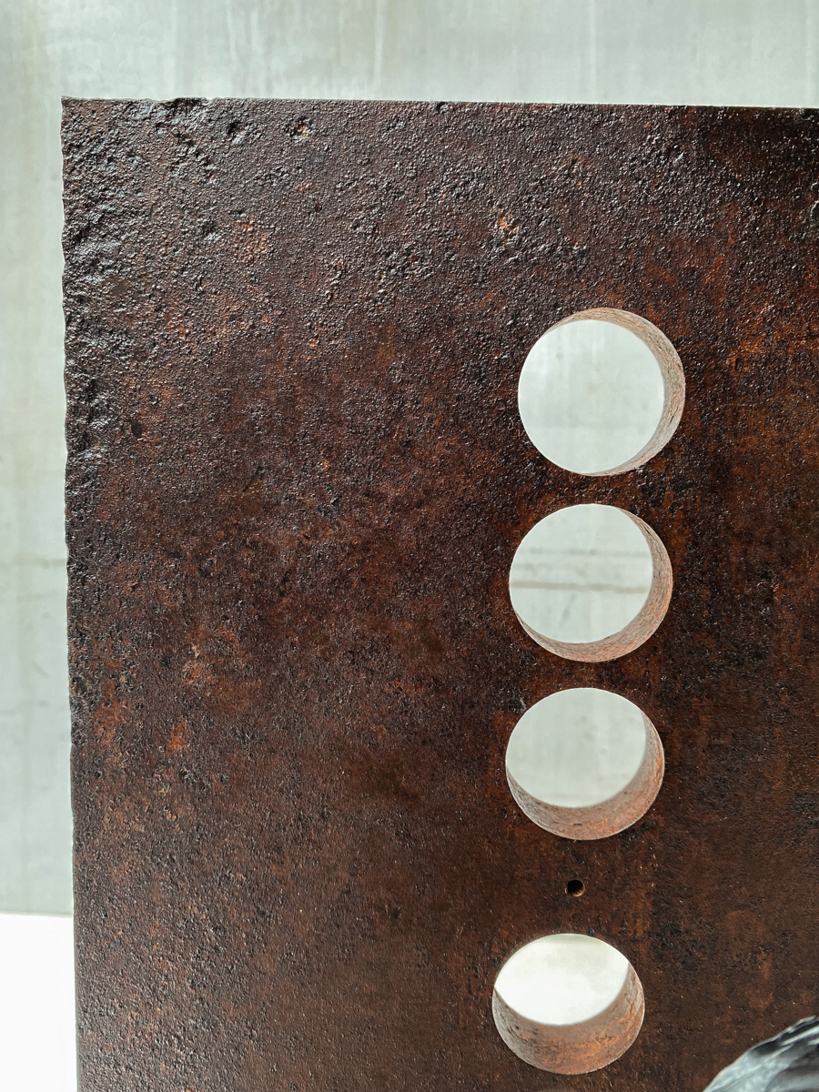 丸い開口が連なる表情豊かな鉄の厚板に、カンガルーアイビーのツルが肩から下がるよう配置した鉄のアート作品です。華やかな大小の葉がリズミカルに連なり、軽やかな印象の彫刻作品になっています。葉の表情。ベースのステンレス板の表情。鉄板の表情。