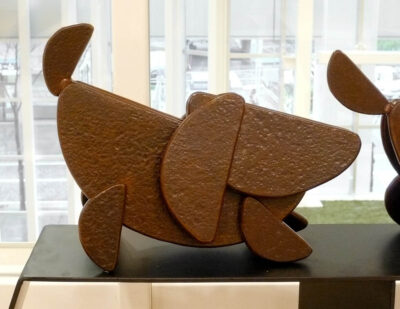 笑顔の口元の形でもある、半円形を集めて作った犬のアート彫刻。思い切り急に立ち止まった子犬です。