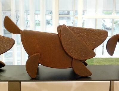 笑顔の口元の形でもある、半円形を集めて作った犬のアート彫刻。急に立ち止まった子犬です。