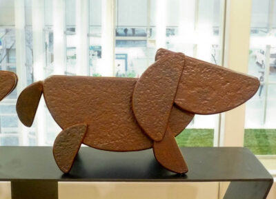 笑顔の口元の形でもある、半円形を集めて作った犬のアート彫刻。ちょっと怖がっている子犬です。
