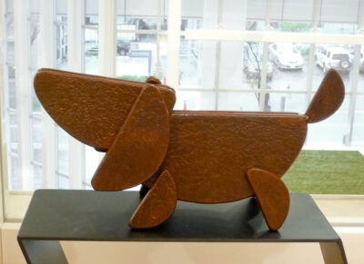 笑顔の口元の形でもある、半円形を集めて作った犬のアート彫刻。元気な子犬です。