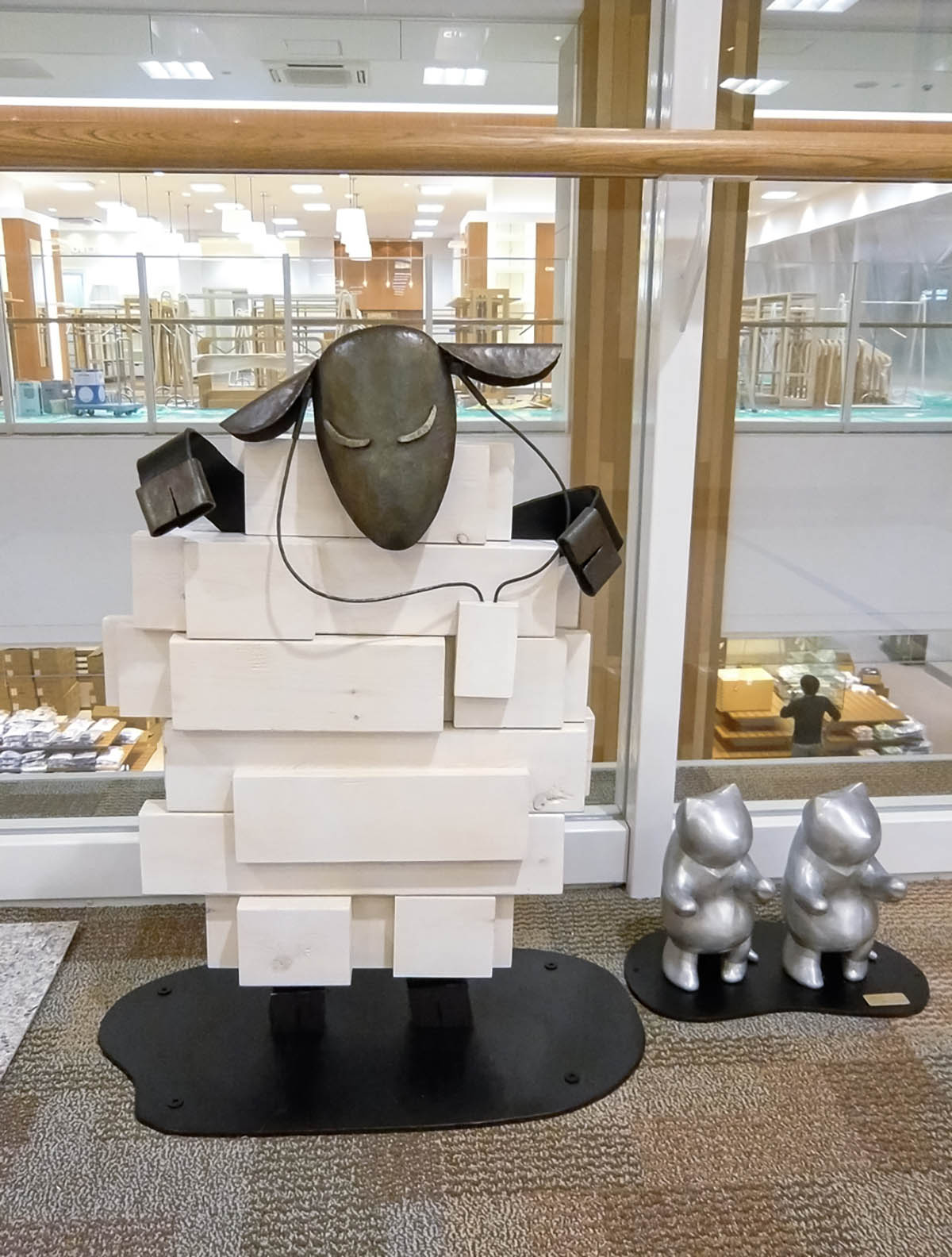 木と鉄で創られた羊のオブジェ彫刻。猫トラップを踊っています。